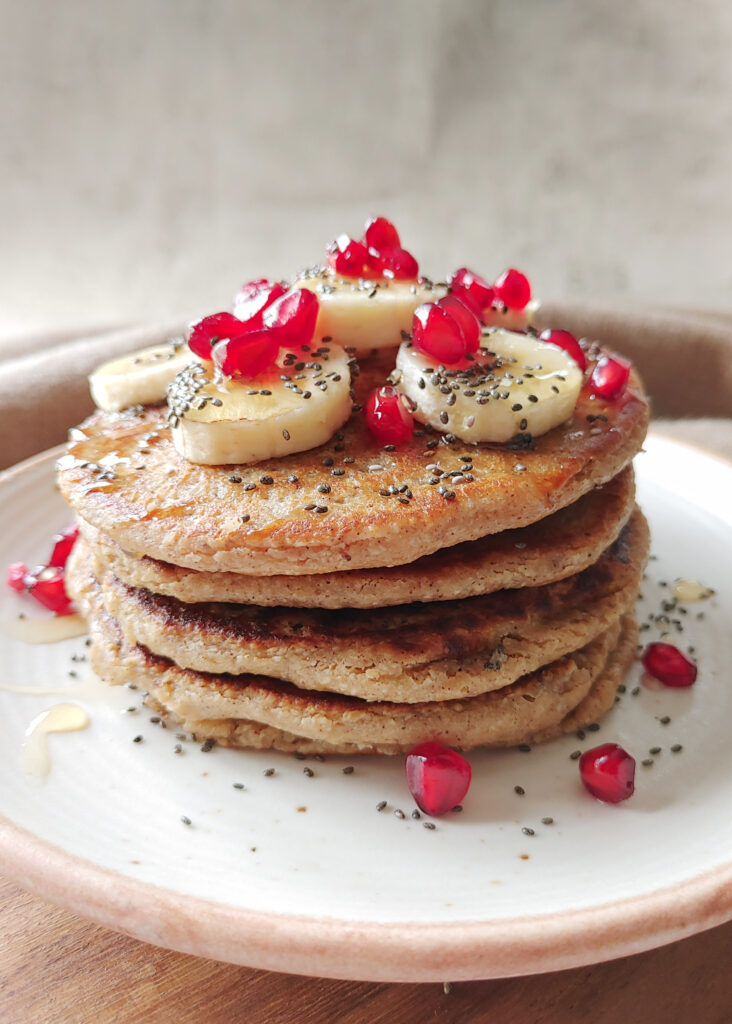 oat banana pancakes stacked with toppings in a plate