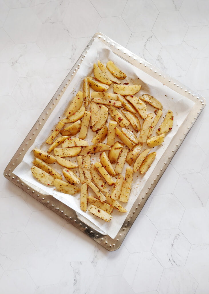 potato wedges in a tray before baking