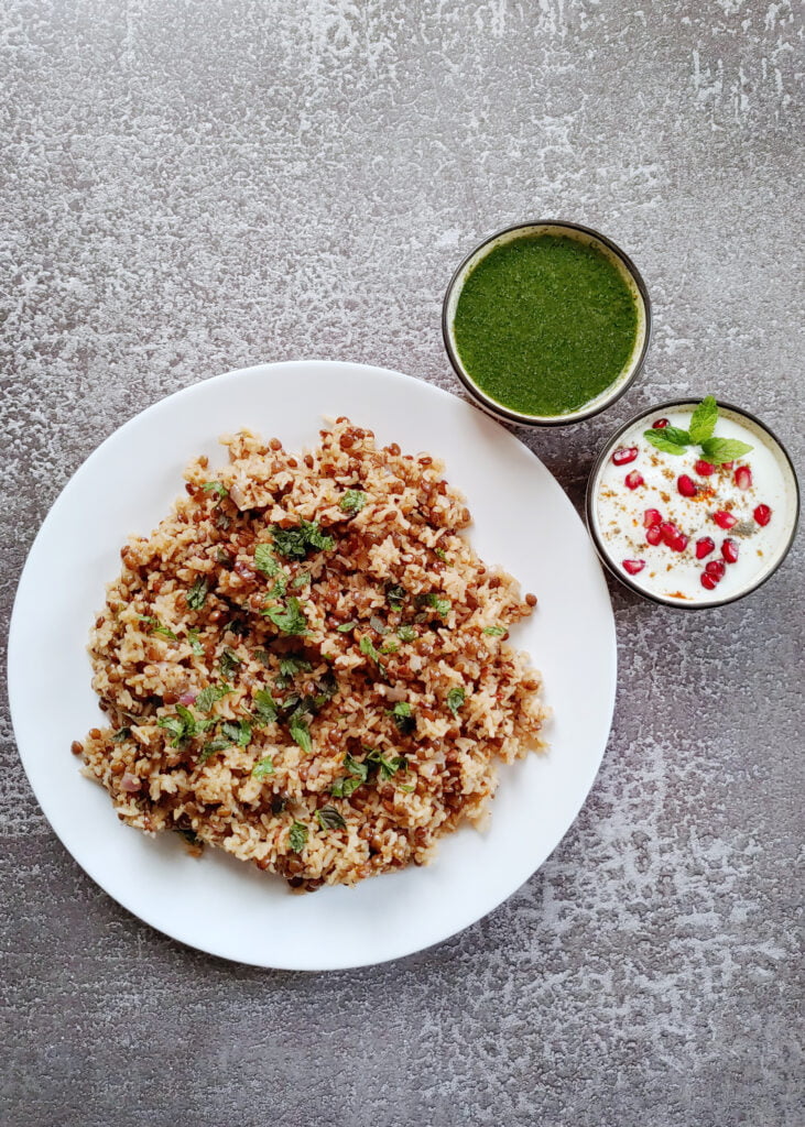 one-pot lentil rice served on a plate with mint chutney and raita