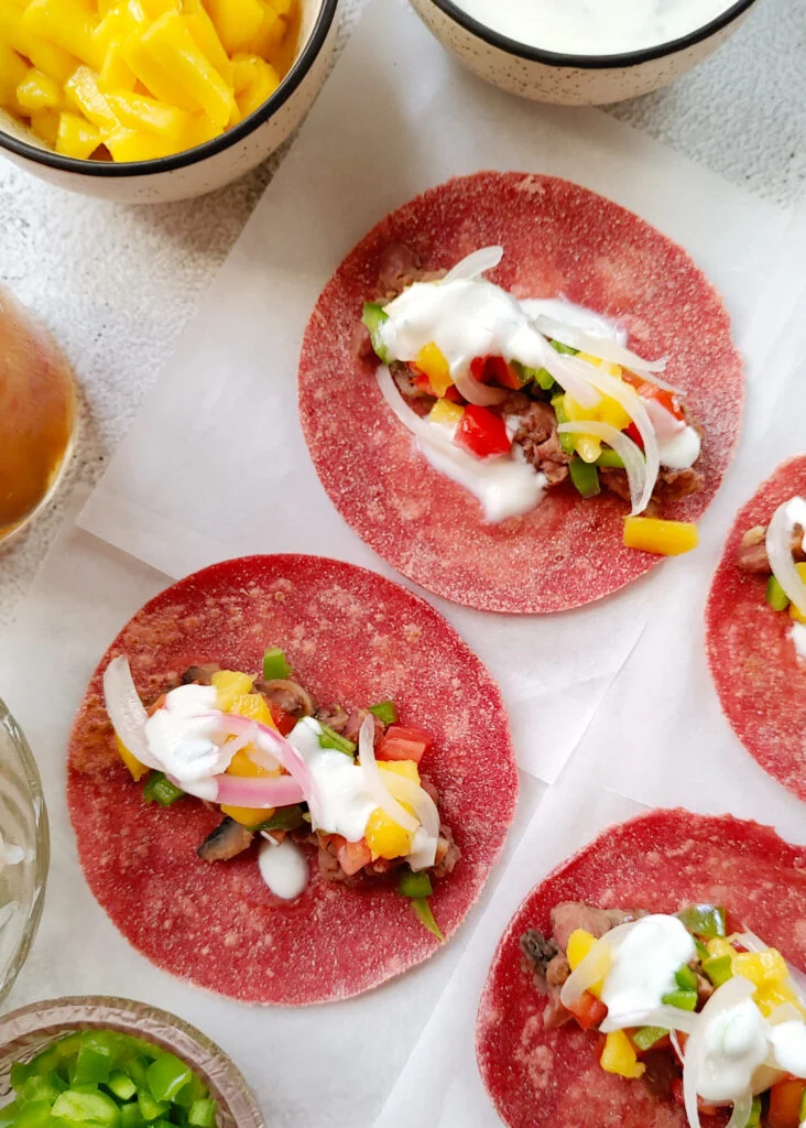 beet tacos with bean and mushroom filling, topped with yoghurt and veggies