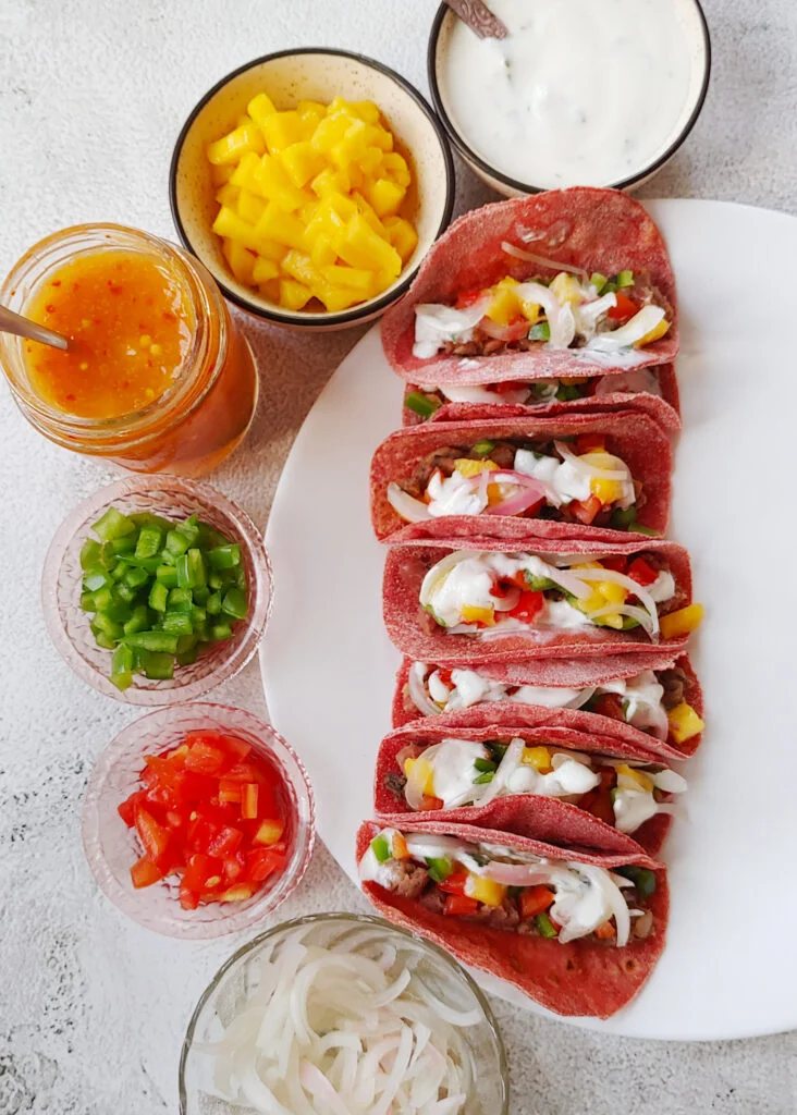 beet tacos with bean and mushroom filling, topped with yoghurt and veggies