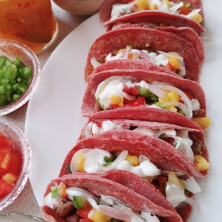 beet tacos with bean and mushroom filling, topped with yoghurt and veggies