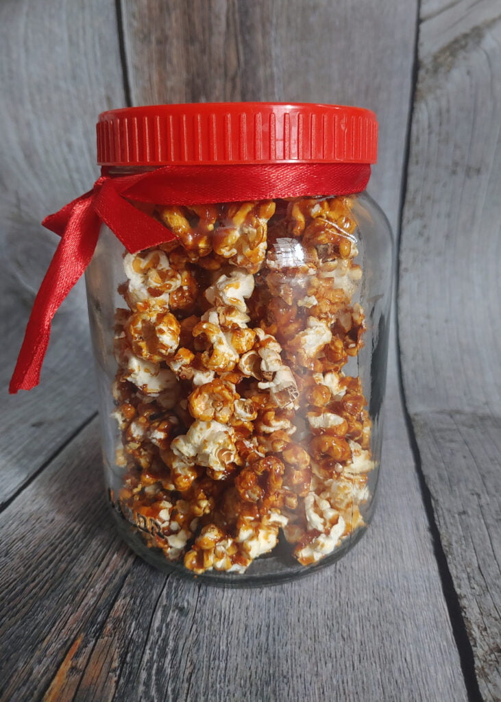 caramel coated popcorn in a glass jar for gifting