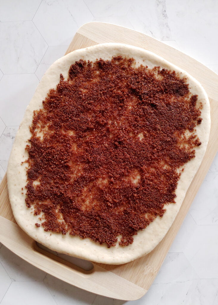 cinnamon roll cookies with cinnamon and brown sugar filling spread over the flattened dough