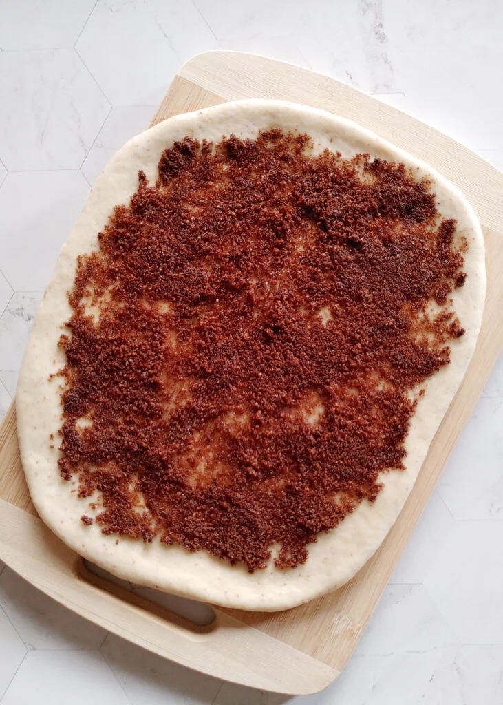 cinnamon roll cookies with cinnamon and brown sugar filling spread over the flattened dough