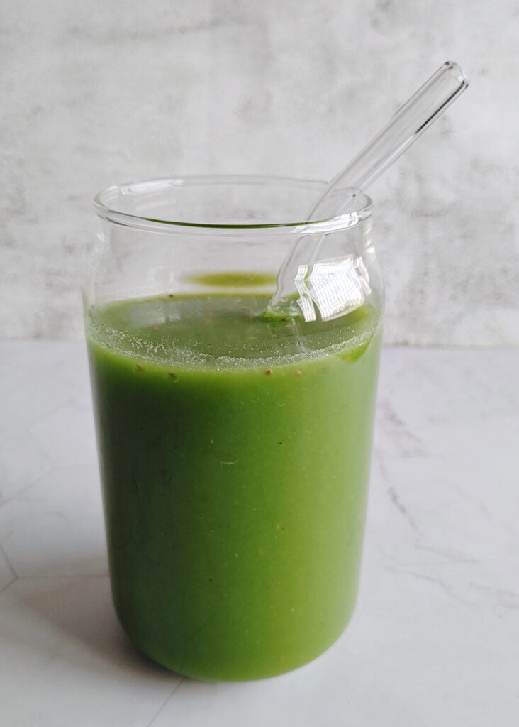 green juice served in a glass with a straw