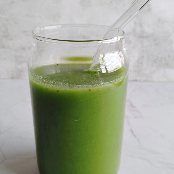 green juice served in a glass with a straw