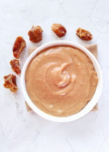 date caramel sauce served in a bowl with few dates kept on the side