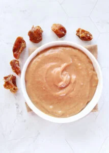 date caramel sauce served in a bowl with few dates kept on the side