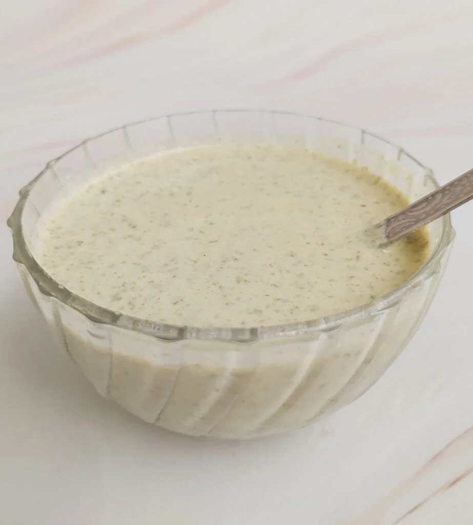 oil - free roasted pumpkin seed dressing served in a glass bowl