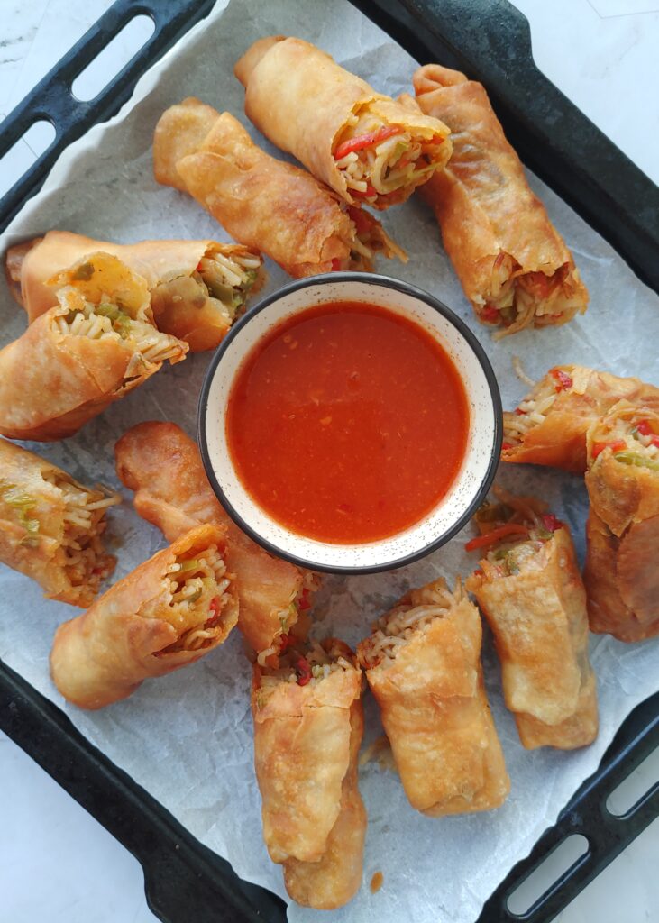vegetable spring rolls in a tray served with a dipping sauce
