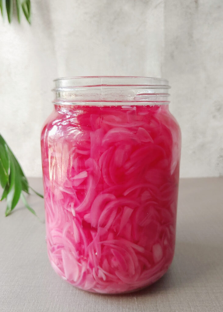 pickled red onions in a glass jar