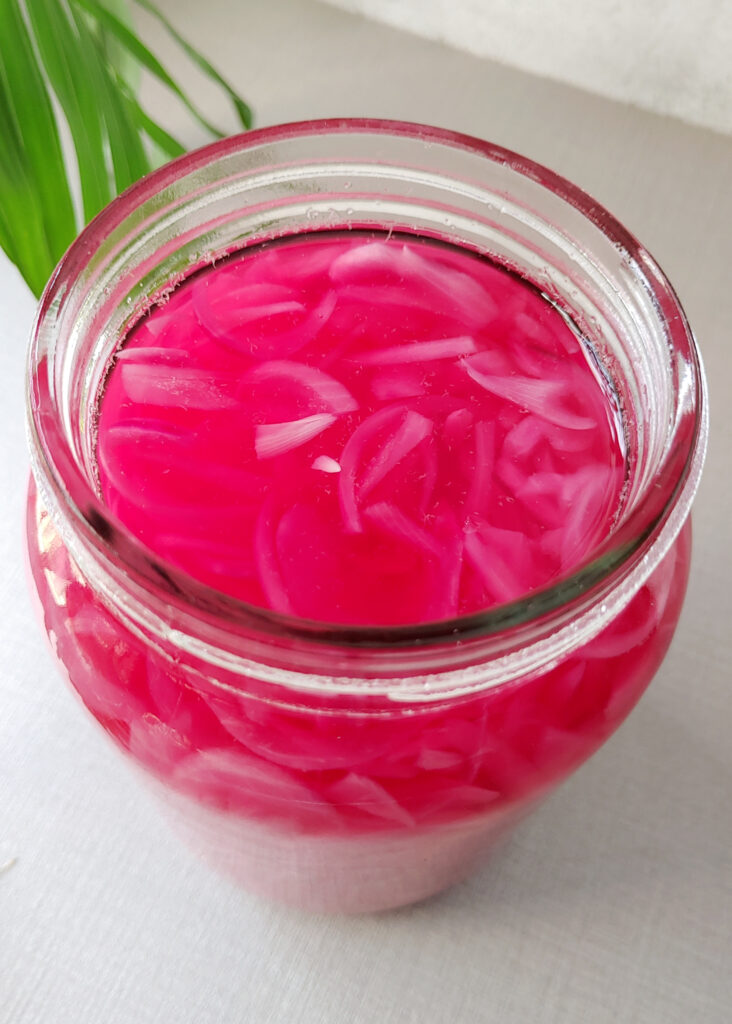 pickled red onions in a glass jar photo from top