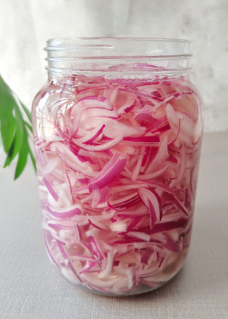 sliced onions soaked in vinegar solution in a glass jar
