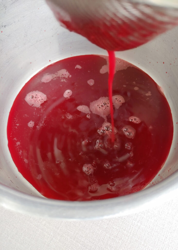 straining ABC juice through a strainer