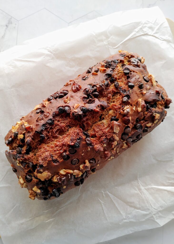 eggless chocolate chip walnut banana bread loaf on a wooden board