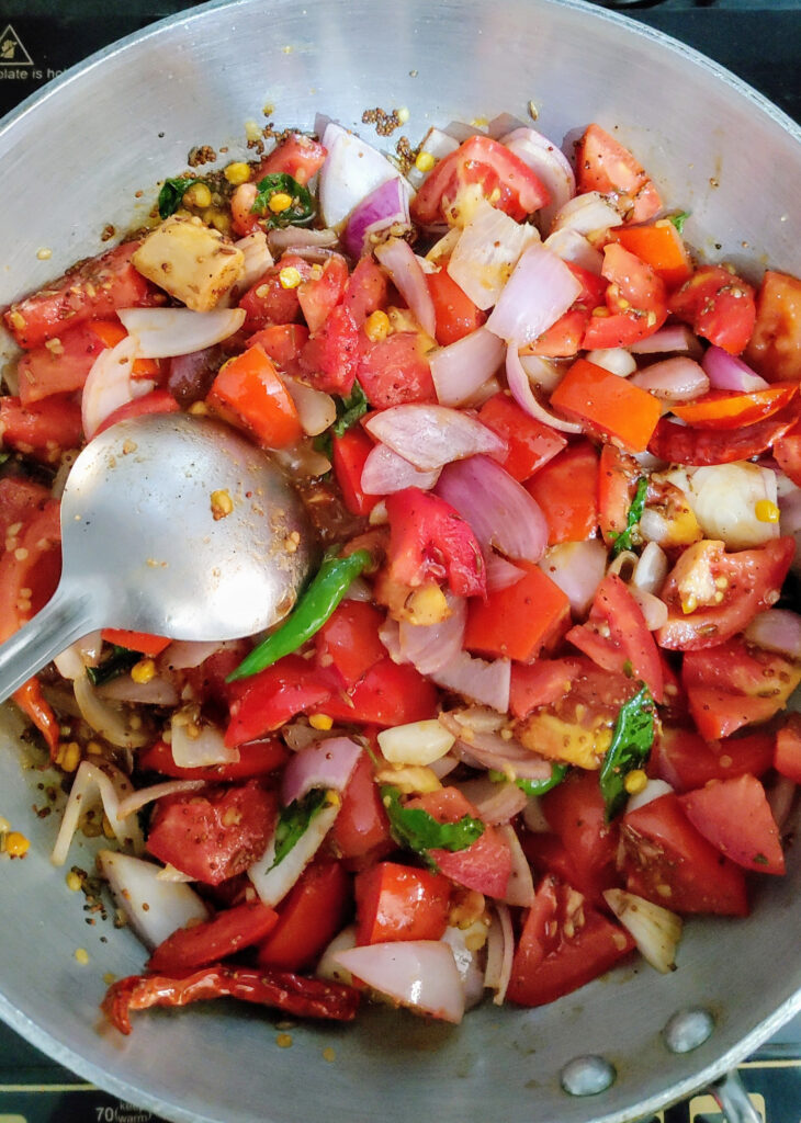 cooking tomato onion chutney in a frying pan
