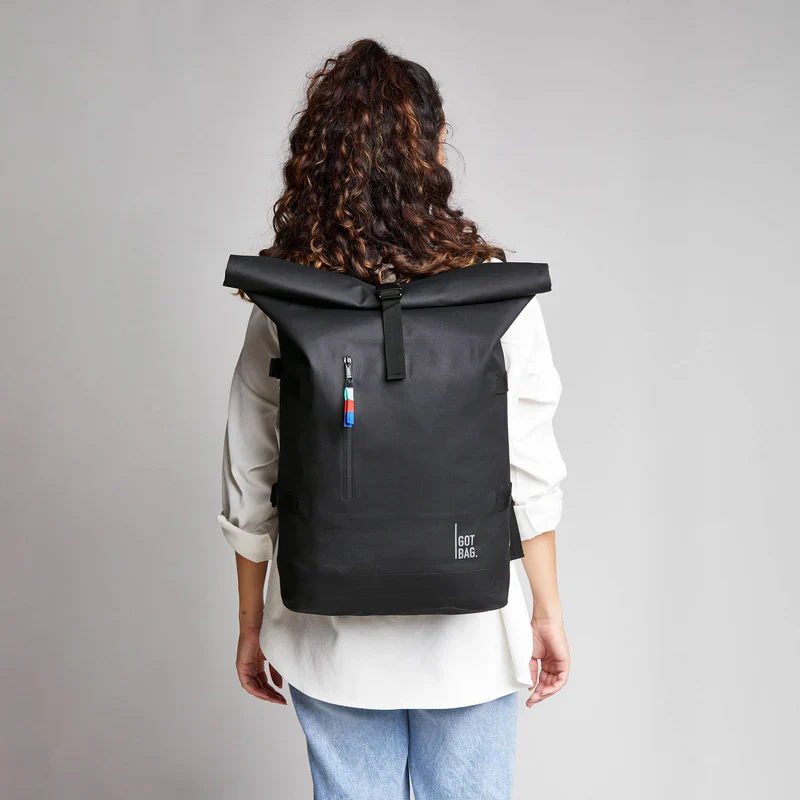 A female carrying GOT rolltop backpack on her back