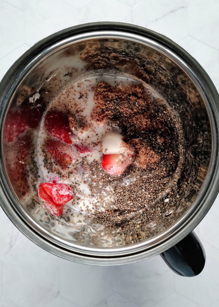 ingredients for strawberry smoothie placed in a blender